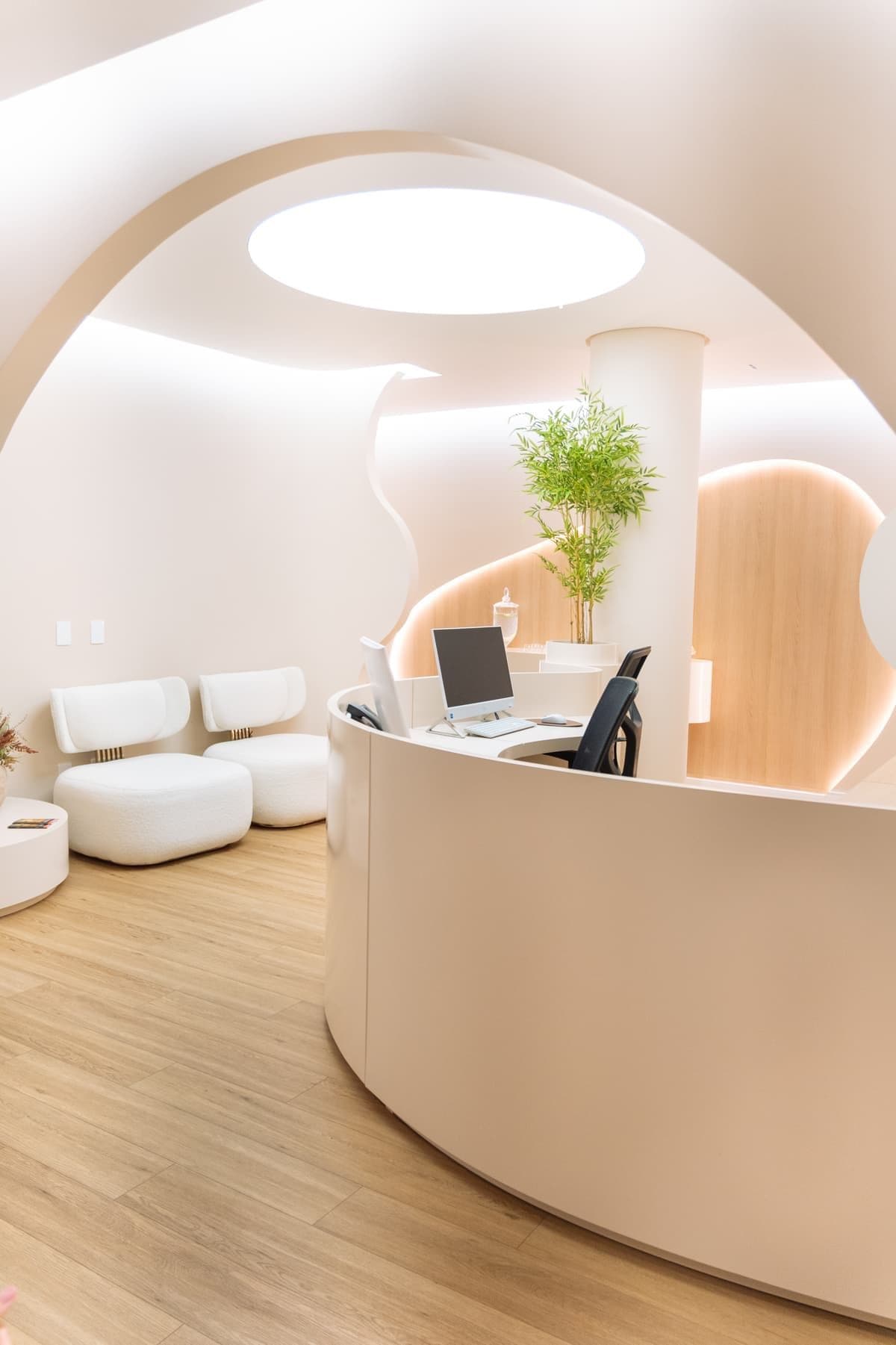 Recepção ampla da Grape Clinic com balcão curvo e iluminação integrada